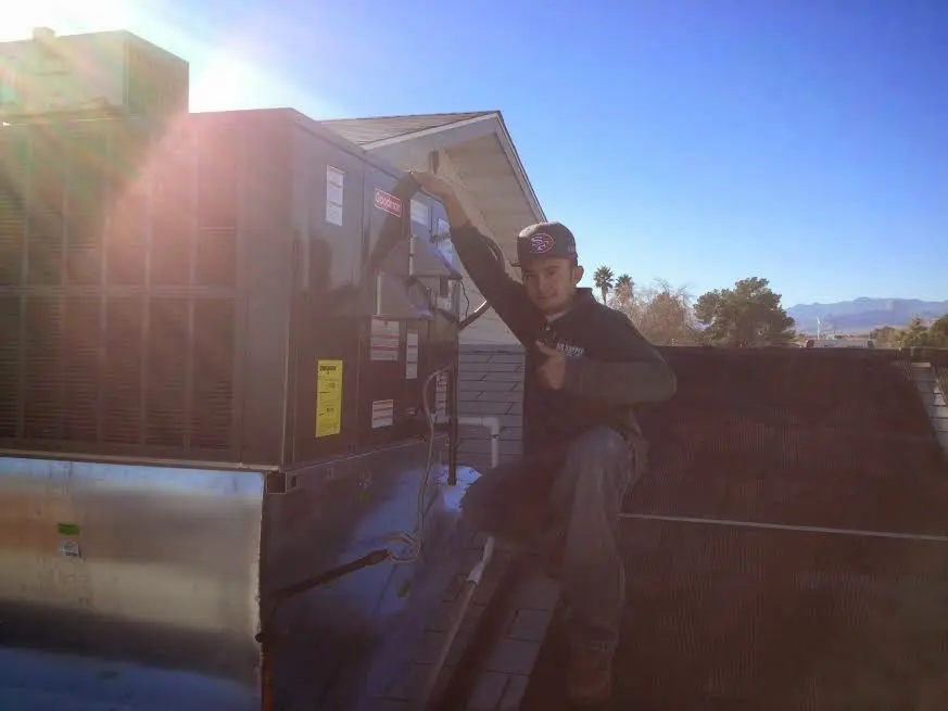HVAC technician performing Air Duct Cleaning on a rooftop unit in Greenwood